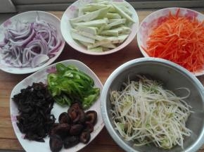 将洋葱切丝、茄子去皮切成约手指宽的细条、胡萝卜切丝、青椒切丝