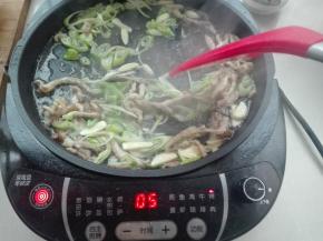 将切好的五花肉丝，放入电饼铛中翻炒，再放入葱蒜翻炒出香味，将其盛出来待用