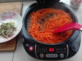 电饼铛中，继续放入胡萝卜丝，同时倒入适量料酒，进行翻炒，炒到软点，盛出来待用。