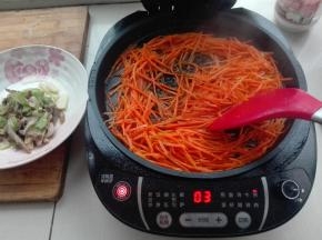 电饼铛中，继续放入胡萝卜丝，同时倒入适量料酒，进行翻炒，炒到软点，盛出来待用。