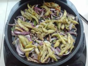 将茄子条在洋葱上面摆放，如图所示。