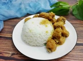 盛一碗米饭放入盘中，再把咖喱排骨放在一边即可食用