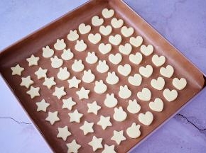 学厨烤盘铺上耐高温不沾布，再把奶片依次放入