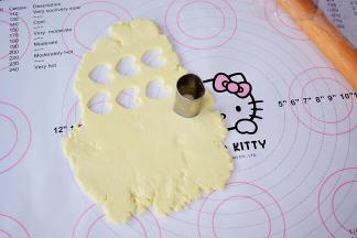 用模具印出形状，剩下的边角料也再次揉成团后再次擀成薄片，再用模具印出形状，依次这样直到奶粉团做完