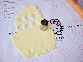 用模具印出形状，剩下的边角料也再次揉成团后再次擀成薄片，再用模具印出形状，依次这样直到奶粉团做完