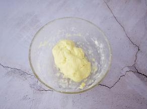 把称好的奶粉放入容器中，边加入牛奶边用刮刀拌，然后用手抓成团，奶粉团不要太软，硬一些为好