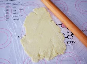 再把奶粉团盖上保鲜膜，再用擀面杖擀成0.3厘米的薄片