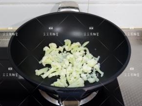 起锅热油，加入菜花煸炒至干燥微焦