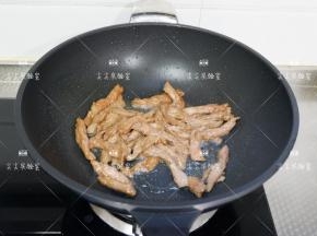 腌制好的牛肉入锅将炒至断生