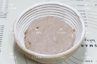 藤篮筛上面粉，将面团放入