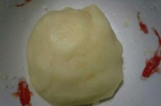 再来制作油酥，油酥部分的糖和面粉拌匀后，把油烧热，趁热倒入面粉中。拌匀成团，可借助刮刀，小心烫手