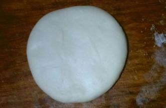 包好的面团，按扁圆，油酥尽量按压均匀