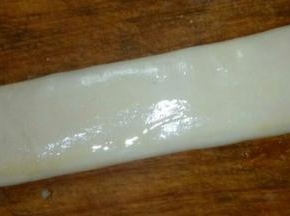 将面团长条按压成扁长状，厚度约为0.6cm,用刷子刷上鸡蛋液