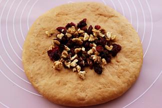 在面团上放入核桃，蔓越莓和红糖。