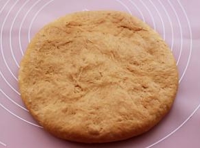 把松驰好的面团再次排气后，用手摁成厚一点的面团。