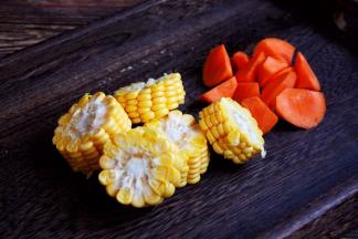 煲排骨汤期间，将玉米切成小段，胡萝卜切成滚刀块备用。