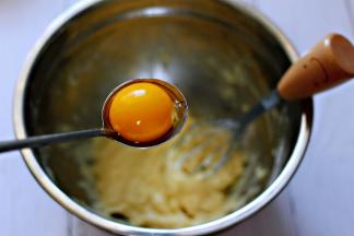  把鸡蛋分出蛋清和蛋黄，放入无水无油的干净盆中，取蛋黄放到面糊中。