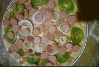 摆上切好的火腿肠片，青椒圈和圆葱圈，也可以根据自己口味放些自己喜欢吃的东西，比如玉米粒，培根，香菇，海鲜或者水果等