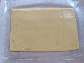 面团取出分成2份，每一份铺在油纸上，盖一层保鲜膜擀成18*26cm的大小，跟枣泥馅大小一致