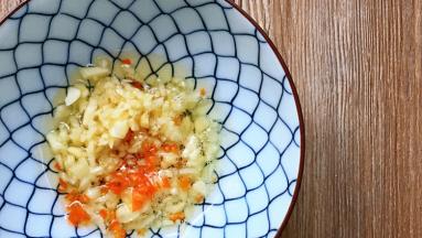 将大蒜碎及红椒碎加入碗中，油烧热，浇在碗中。