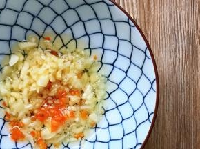 将大蒜碎及红椒碎加入碗中，油烧热，浇在碗中。