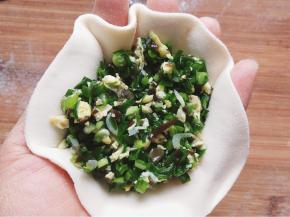 取一个面皮放入收拢弯曲的左手中，盛馅