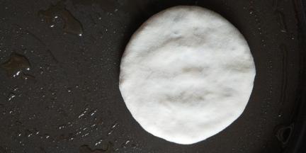 平底锅中小火预热好以后抹少许油，放入做好的饼，边旋转饼胚，边轻轻摁压至合适的厚度（注意千万不能用蛮力）。如果担心摁压掌握不好，提前擀薄再入锅烙也好，不过我还是觉得在锅内轻轻旋转着摁压更好掌握