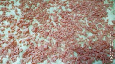 将火腿粒撒在面片上。