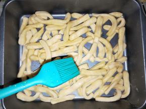 不沾烤盘铺上一层面条，刷一层麦芽糖，铺一层果仁