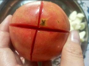 煮面期间把西红柿洗净，顶部切十字花，用开水烫一下，剥去外皮，切成西红柿丁备用