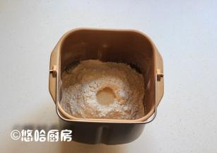 在液体是上面放入面包粉，让面包粉覆盖住液体即可，在面粉的上面用手指戳个窝，放入1小勺干酵母。