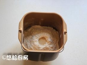 在液体是上面放入面包粉，让面包粉覆盖住液体即可，在面粉的上面用手指戳个窝，放入1小勺干酵母。