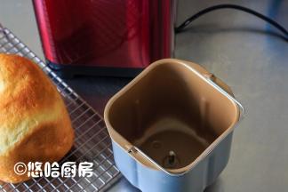 倒扣出面包至网架上放凉，看桶内一点没粘，不过那搅拌刀卡在面包里了。