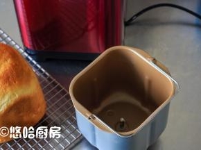 倒扣出面包至网架上放凉，看桶内一点没粘，不过那搅拌刀卡在面包里了。