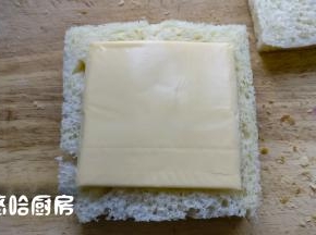 盖上一片吐司，上面放芝士片，再盖上一片吐司，从对角线切开也行，从中间切开也行，根据自己的喜好来哦。