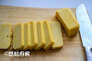 放凉后的年糕倒扣在案板上，切片。放凉的黄面糕很硬，不好吃。