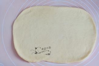 取出发酵好的面团，松弛后擀成长方形状。