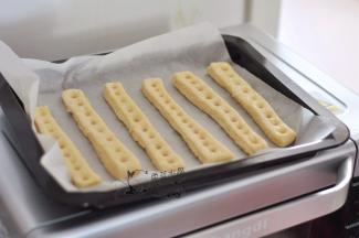 取出烤盘，在每个面条上用筷子按压小孔，表面再刷一层蛋液。