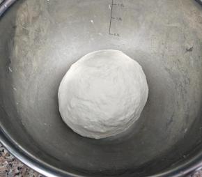 把面粉加入温水和成团，盖上湿布松弛30分钟。