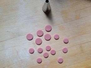 红色面团擀薄片，用合适的裱花嘴压出5个大一点的圆，10个小一点的圆