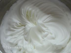 接着加入剩余细砂糖的一半。继续高速打发，让蛋白霜更加坚挺，蛋白霜更加有光泽感，大约1分钟。