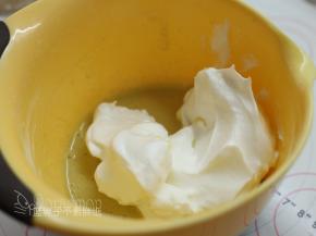 取1/4的蛋白霜加入到蛋黄糊中，用橡皮刮刀用翻拌的手法拌匀。