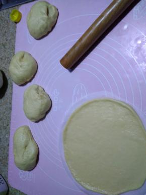 将发酵好的面团均匀切成5份等量的小面团，盖保鲜膜显面15分钟，剪一个8寸蛋糕纸垫