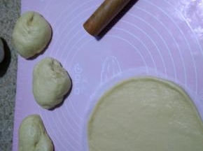 将发酵好的面团均匀切成5份等量的小面团，盖保鲜膜显面15分钟，剪一个8寸蛋糕纸垫