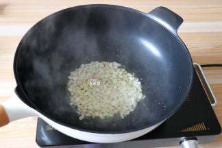 锅热后倒入适量玉米油，倒入洋葱翻炒出香味；