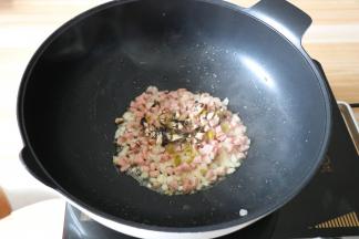 倒入香菇丁、腌绿辣椒丁煸炒熟，快出锅的时候加入少许盐翻炒均匀；
