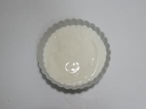 将酸奶倒入装有麦片的碗中备用