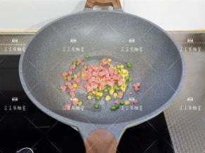 起锅，加一点点油烧热，下入玉米粒、豌豆粒、火腿丁