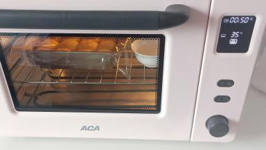 放入北美ACA ATO-E43A电烤箱，里面放一碗水。开启烤箱发酵功能温度调制35度，时间50分钟进行二发。