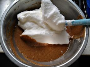 将三分之一蛋白霜放入蛋黄糊中，用刮刀翻拌均匀